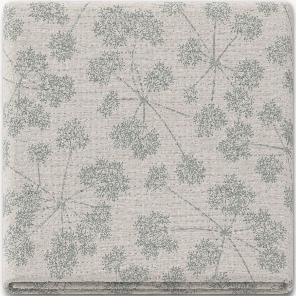 A folded piece of textured fabric with a repeating pattern of muted sage green dandelion-like floral clusters on a warm off-white background.